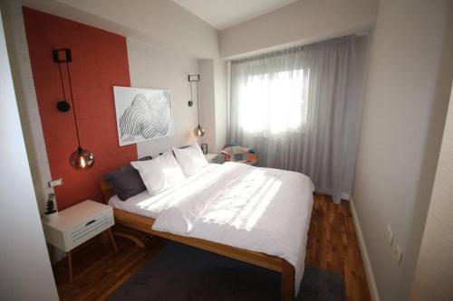 斯科普里Kristina's Cozy Designer Apartment的卧室设有一张白色大床和一扇窗户。