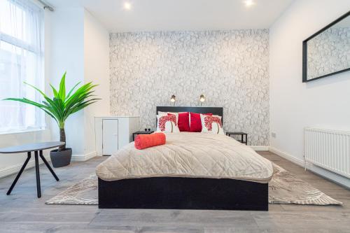 利物浦The Blossoms Studio Apartments的一间卧室配有一张带红色枕头的床和一张桌子
