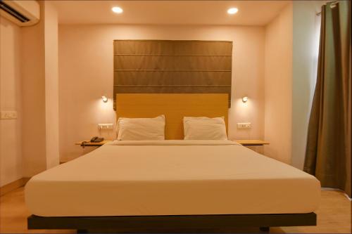 GauripurFabHotel Suncitel Dum Dum Airport的卧室配有一张白色大床和床头板