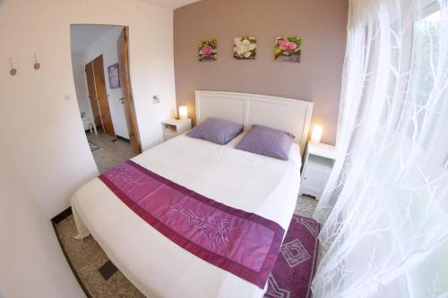 Hellemmes-Lille亚当酒店的卧室配有一张大白色床和紫色床单