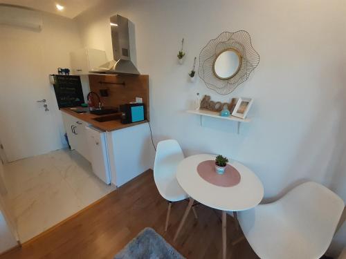 赫瓦尔Barko apartment and rooms的厨房配有白色的桌椅和镜子