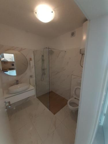 赫瓦尔Barko apartment and rooms的带淋浴和卫生间的白色浴室