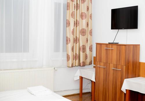 GherlaCasa Zâna Bună的一间房间,配有一个橱柜和窗帘,电视在橱柜和窗帘