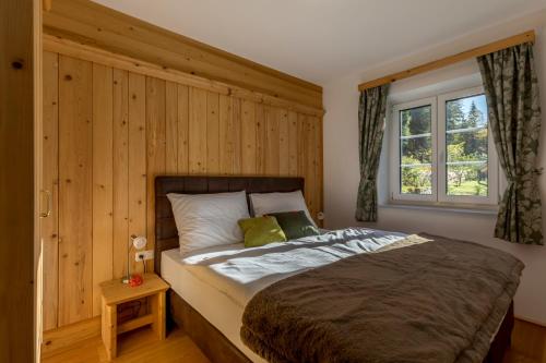 茵特斯托德Appartement Hess Hinterstoder的一间卧室设有一张带木墙的大床
