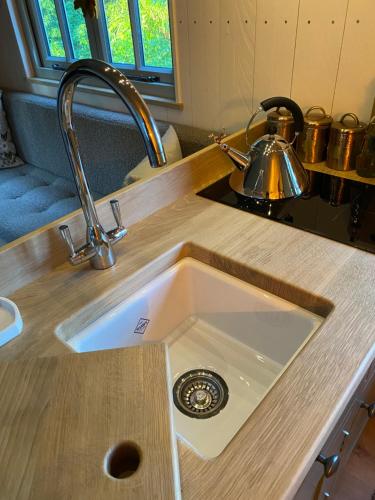 KellingChez Maurice Luxury Shepherds Hut with Bath and Hot Tub的厨房水槽位于带茶壶的柜台