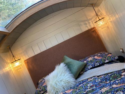 KellingChez Maurice Luxury Shepherds Hut with Bath and Hot Tub的一间卧室配有一张带木制床头板的床