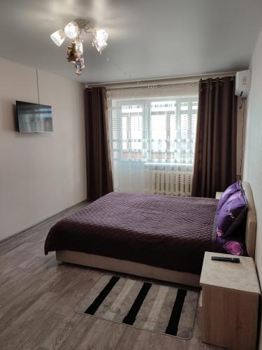伊兹梅尔Аренда квартиры的一间卧室设有紫色的床和窗户