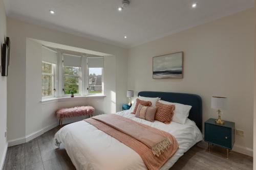 Blackford3 bedroom Windsor Garden apartment by Gleneagles的一间卧室设有一张大床和两个窗户。