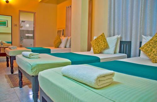 布莱尔港Kokari Guesthouse的酒店客房,配有四张床和毛巾