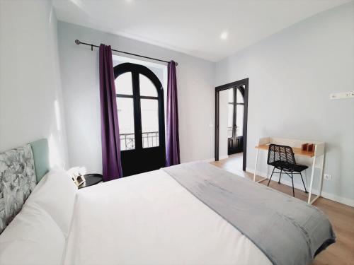 萨拉曼卡Apartamentos Vega by gaiarooms的卧室配有一张白色大床和一把椅子