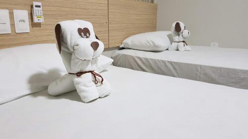 阿尔科韦迪Max Hotel的两只填充的动物坐在两张床上