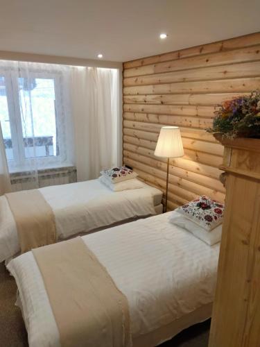 扎科帕内Anielki Apartament的卧室设有两张床铺和木墙