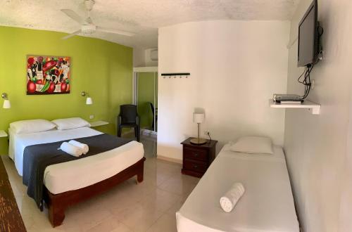 佩德纳莱斯Hotel Pedernales Italia Republica Dominicana的一间卧室配有两张床和一台平面电视