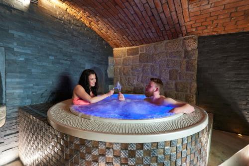 利贝雷茨Hotel Stará Pekárna s privátním wellness的坐在热水浴缸中的男人和女人