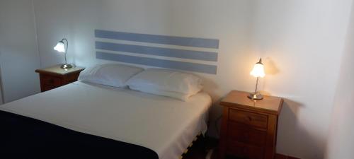 卡武埃鲁Quinta Das Amendoas的一间卧室配有一张带两张台灯的床铺。