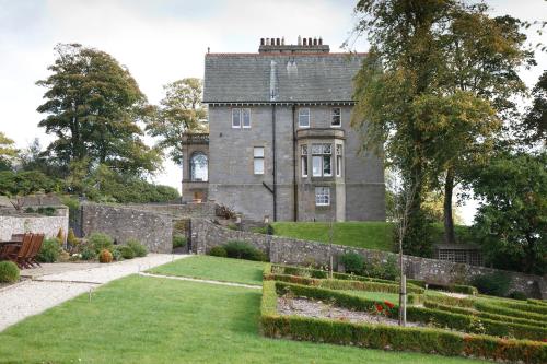 邓弗姆林巴尔穆勒之家酒店的一座古老的城堡,前面有一个花园