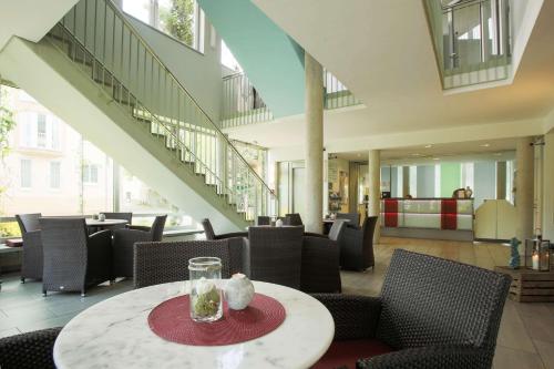 不来梅港弗洛登齐尔大西洋酒店的一间带桌椅和楼梯的餐厅