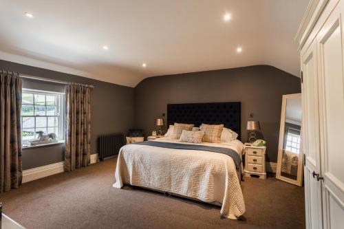Chatton珀西阿姆斯酒店的一间卧室设有一张大床和一个窗户。