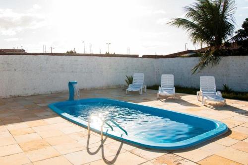 GuamaréHotel Ouro Negro的一个带两把草坪椅的游泳池
