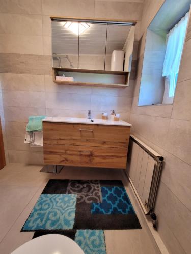 格勒迪希Ferienwohnung Anna的浴室设有水槽、镜子和地毯。