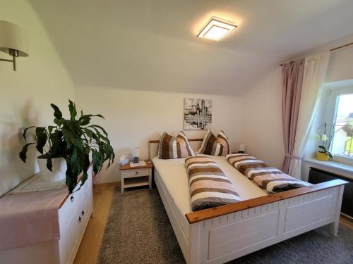 格勒迪希Ferienwohnung Anna的一间卧室设有两张床和盆栽植物