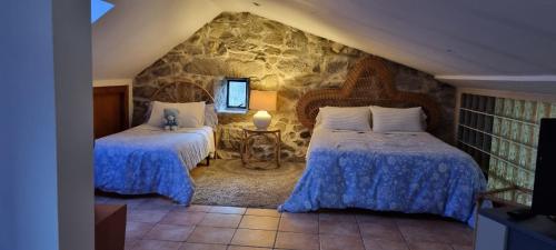 维拉波Casa do Crego的一间卧室设有两张床和石墙