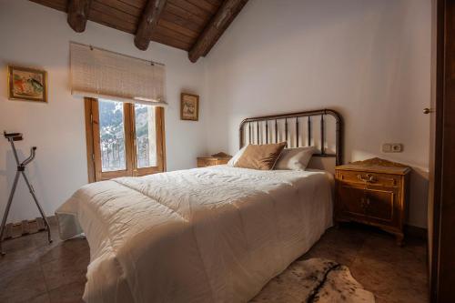 PratsJAT MOUNTAIN HOUSES - Casa Jarca 2on pis Àtic, a 1km de Canillo的一间卧室设有一张大床和一个窗户。