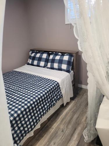 巴里Adorable Studio Basement Suite in South Barrie的一间卧室配有一张带蓝色和白色床单的床。