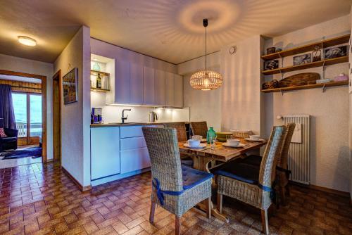 拉茨欧马兹Appartement Bellevue 207的厨房以及带桌椅的用餐室。