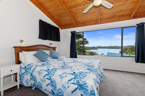 拉塞尔Brind Lodge - Russell Holiday Home的一间卧室设有一张床和一个大窗户