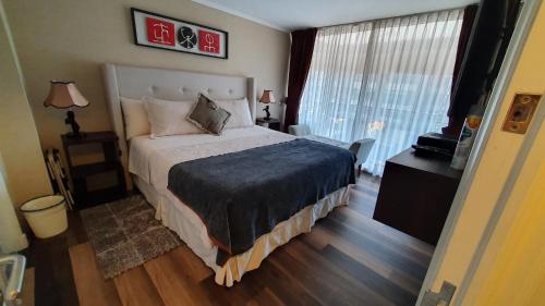 圣地亚哥Mojens Suites Santiago的一间卧室设有一张大床和一个大窗户