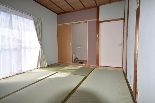 KaiyoGuest House Fuku-chan的一间空房间,设有大窗户和地板