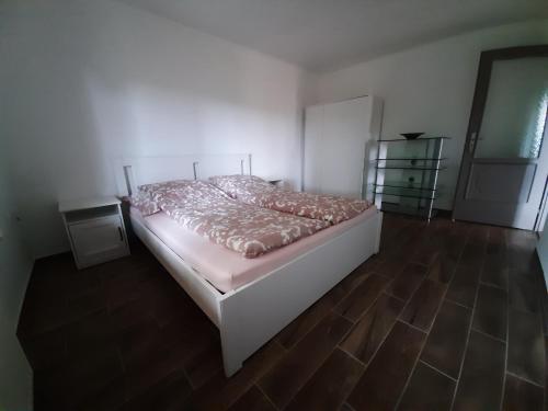 FelsőörsForrás-hegyi Apartman的一间卧室配有一张床,铺有木地板