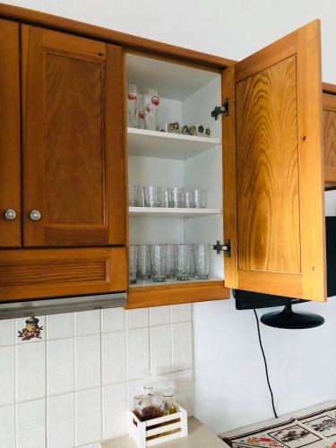 帕罗斯岛fanis sweet home的厨房配有木柜,架子上装有玻璃杯