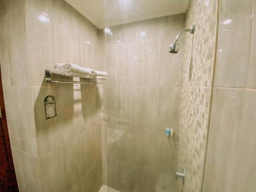 塞尔蓬Sapphire Sky Hotel & Conference的浴室里设有玻璃门淋浴