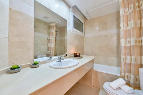 卡尔佩Villas Guzman - Apartamento Tramontana的一间带水槽、卫生间和镜子的浴室