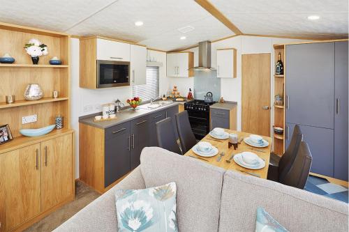 纽基Newquay Bay Resort的一间厨房和客厅,客厅配有大篷车内的桌子