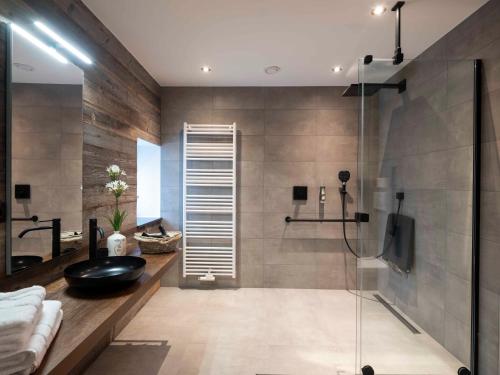 胡法利兹La Maison du Notaire的浴室设有玻璃淋浴间和黑色水槽