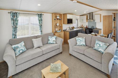 纽基Newquay Bay Resort的一间带两张沙发的客厅和一间厨房