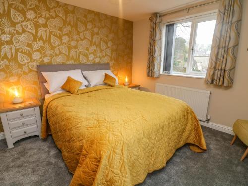 克利夫罗Market Lounge的一间卧室配有一张带黄色床罩的床和窗户