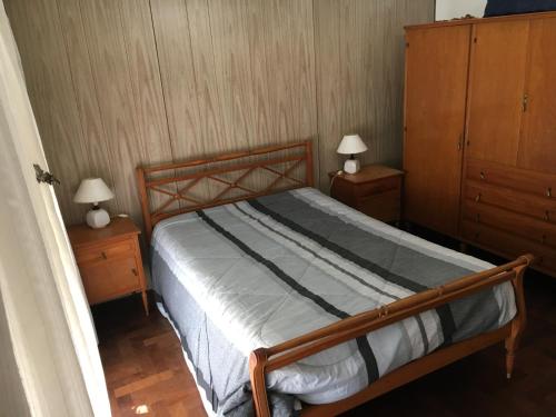 马德普拉塔Lo de Dora的一间卧室配有木床和2个床头柜
