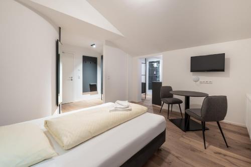施图拜河谷新施蒂夫特Appartements zur Sonne的酒店客房配有一张床铺和一张桌子。