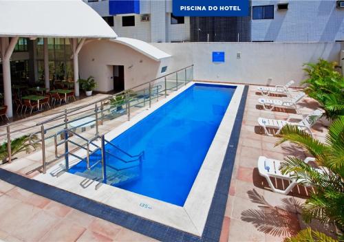纳塔尔纳塔尔潘塔内格拉智选假日酒店的一个带椅子和桌子的大型游泳池