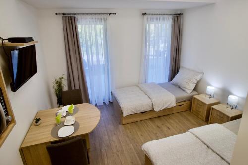 帕波Sport Centrum Apartman的一个小客厅,配有一张床和一张桌子
