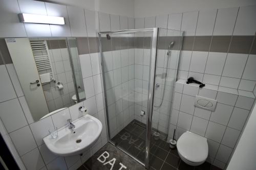 帕波Sport Centrum Apartman的带淋浴、盥洗盆和卫生间的浴室