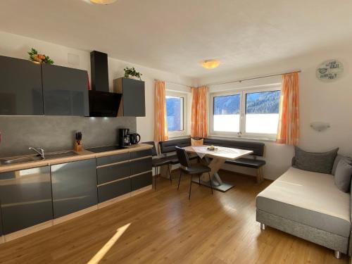 希帕赫Apartment Schöser - MHO779 by Interhome的厨房以及带桌子和沙发的客厅。