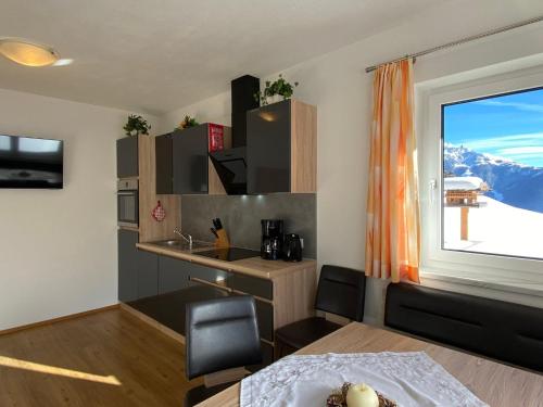 希帕赫Apartment Schöser - MHO779 by Interhome的带桌子的客房和带窗户的厨房