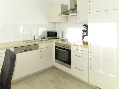奇勒谷地拉姆绍Apartment Hanser - MHO754 by Interhome的白色的厨房配有水槽和微波炉