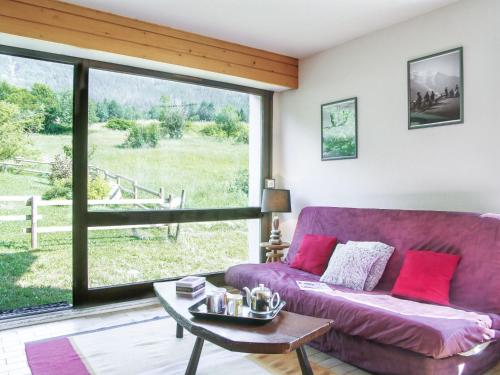 夏蒙尼-勃朗峰夏蒙尼波拉尔尼斯II因特尔之家度假屋的客厅配有紫色沙发和大窗户