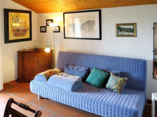 拉卡诺奥肯Apartment Petite Ramaline - LCA166 by Interhome的客厅配有蓝色沙发及枕头